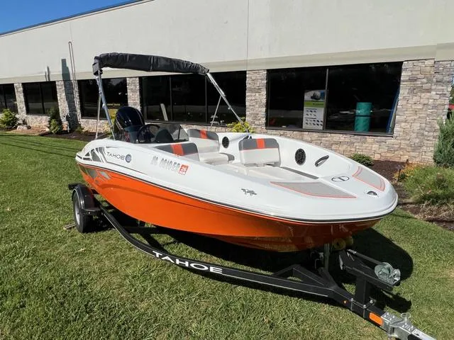 Slide: The Image of 2020 Tahoe T16 boat with orange and white design on a trailer, parked on grass. - 4