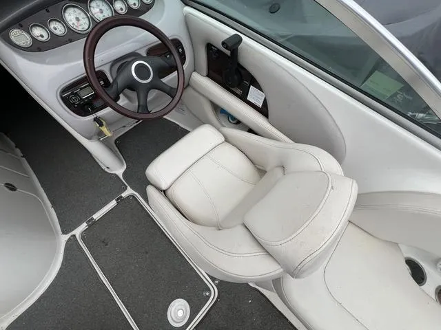 Slide: The Image of 2005 Chaparral Sunesta 236 boat interior with steering wheel and white seating. - 10