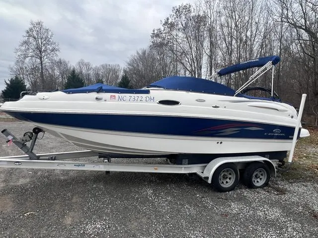 Slide: The Image of 2005 Chaparral Sunesta 236 boat on trailer, parked outdoors in wooded area. - 3