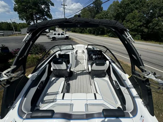 Slide: The Image of 2022 Yamaha Boats 212XD interior, sleek design, spacious seating, modern dashboard, outdoor setting. - 10