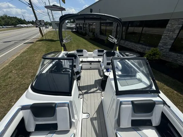 Slide: The Image of 2022 Yamaha Boats 212XD, sleek interior design, parked outdoors near a road. - 5