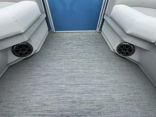 Slide: The Image of 2024 Godfrey Xperience 2286 SBX boat interior with gray flooring and built-in speakers. - 9