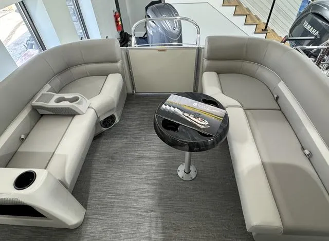 Slide: The Image of 2024 Godfrey Xperience 2286 SBX pontoon boat interior with plush seating and sleek table. - 3