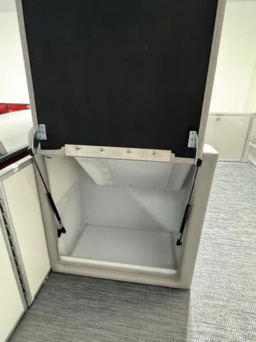 Slide: The Image of 2024 Godfrey Xperience 2286 SBX storage compartment with open lid and hydraulic supports. - 5