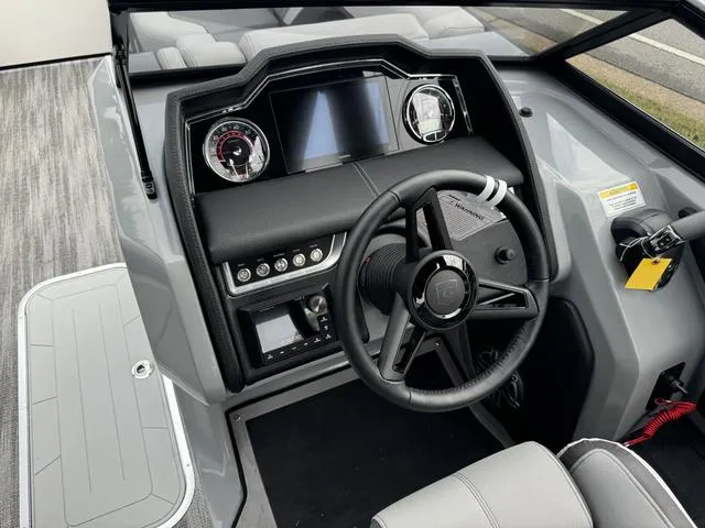 Slide: The Image of 2025 Godfrey AP235 ULW boat dashboard with steering wheel and modern controls. - 15
