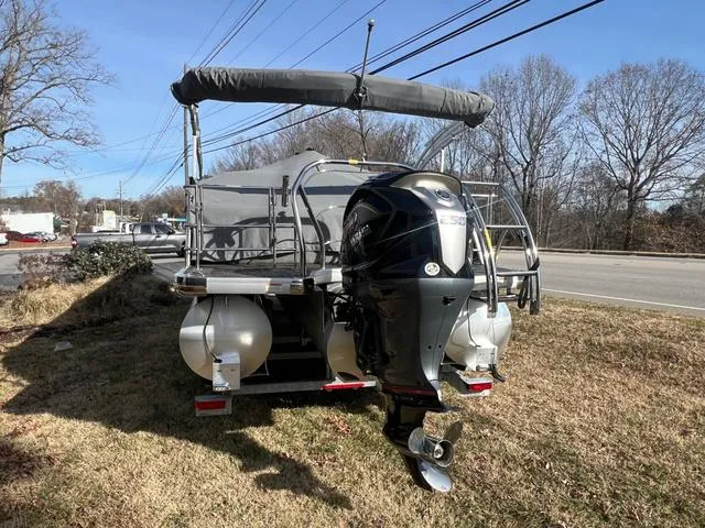 Slide: The Image of 2022 Godfrey Monaco 235 SFL pontoon boat with outboard motor on grassy area. - 13