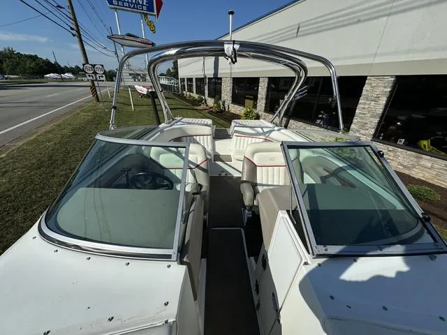 Slide: The Image of 2005 Cobalt 262 boat with open seating, parked near a service center. - 12