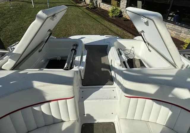 Slide: The Image of 2005 Cobalt 262 boat interior with open storage compartments and white seating. - 15