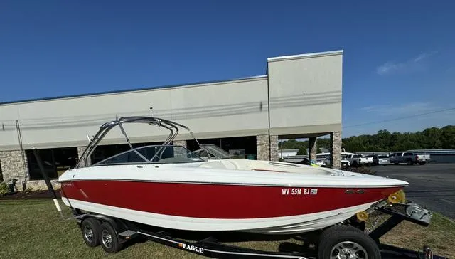 Slide: The Image of 2005 Cobalt 262 boat on trailer, red and white, parked outside a building. - 3
