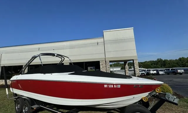 Slide: The Image of Red and white 2005 Cobalt 262 boat on trailer, parked near a building. - 4