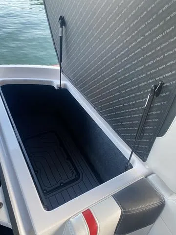 Slide: The Image of 2014 Nautique Super Air G23 storage compartment open on water. - 13