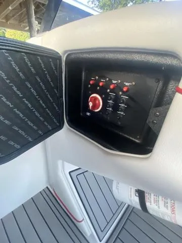 Slide: The Image of Control panel of 2014 Nautique Super Air G23 boat with switches and fire extinguisher. - 19
