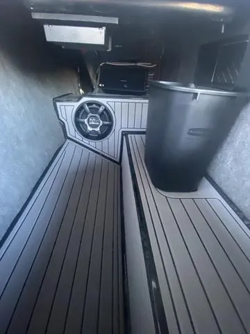 Slide: The Image of Interior of 2014 Nautique Super Air G23 boat with sleek flooring and storage space. - 22