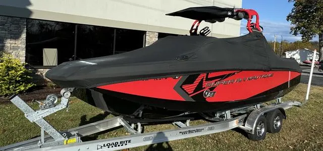 Slide: The Image of 2014 Nautique Super Air G23 boat on trailer, covered, red and black design. - 3