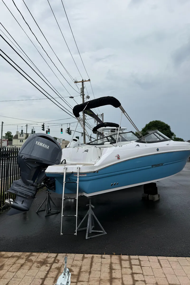 Slide: The Image of 2025 Stingray 211 DC boat with Yamaha engine on display outdoors. - 2