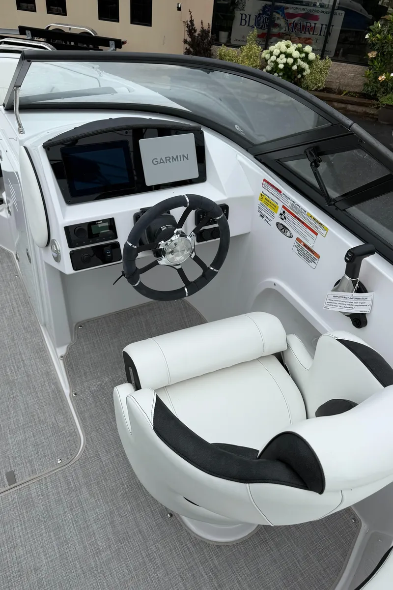 Slide: The Image of 2025 Stingray 211 DC boat cockpit with Garmin navigation system and plush seating. - 7