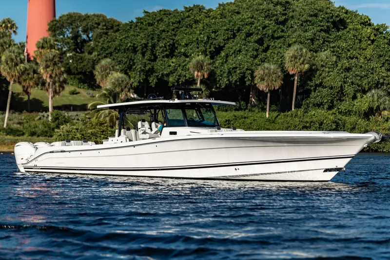 The Image of 2019 HCB 53 boat cruising on a scenic waterway with lush greenery. - 0