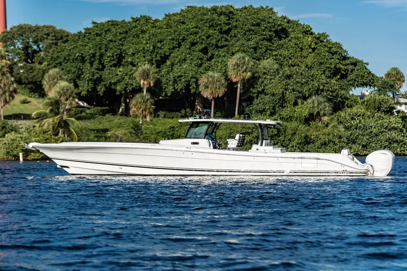 Slide: The Image of 2019 HCB 53 boat cruising on a scenic waterway with lush greenery. - 4