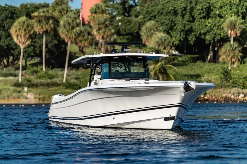 Slide: The Image of 2019 HCB 53 boat cruising on a scenic waterway with lush greenery. - 6