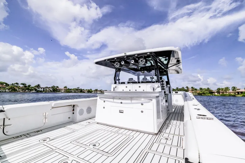 Slide: The Image of 2019 HCB 53 boat with spacious deck, sleek design, and scenic water view. - 7