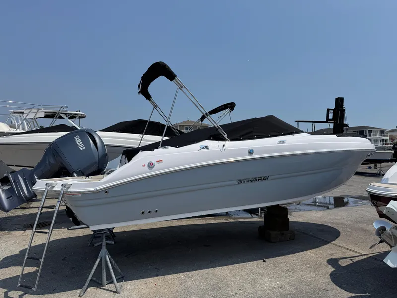 Slide: The Image of 2025 Stingray 211 DC boat with Yamaha engine on display outdoors. - 0