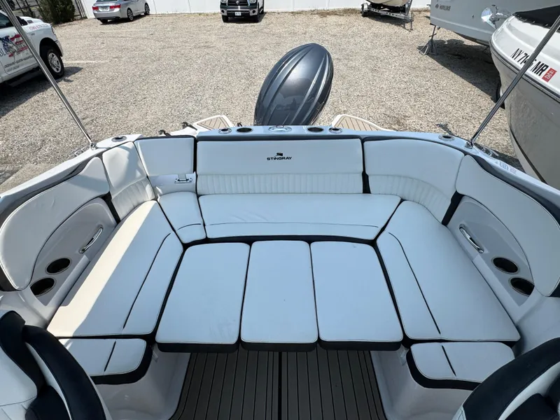 Slide: The Image of 2025 Stingray 211 DC boat interior with white cushioned seating and sleek design. - 21