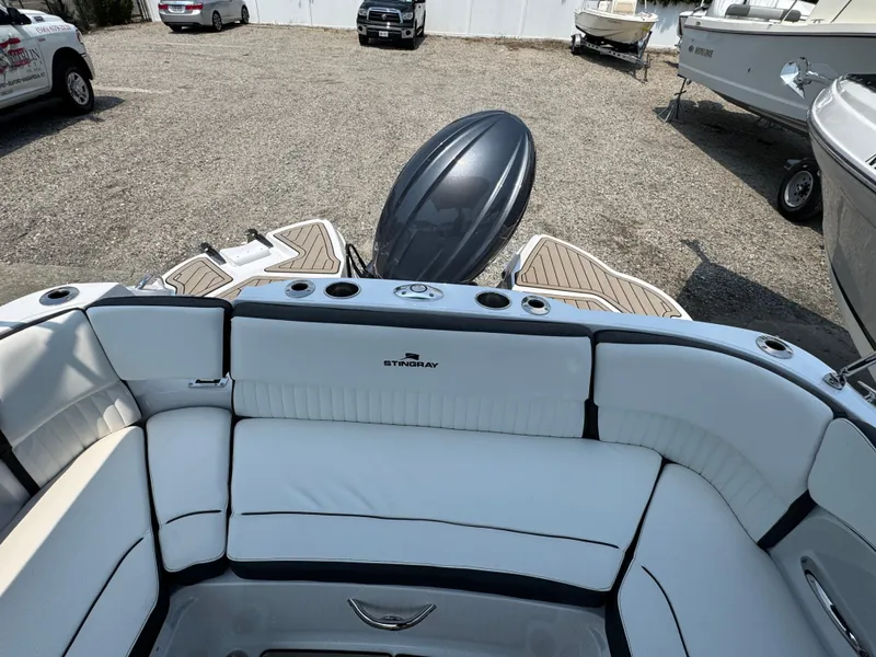 Slide: The Image of 2025 Stingray 211 DC boat interior with white seating and outboard motor. - 5