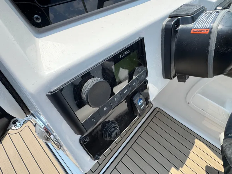 Slide: The Image of 2025 Stingray 211 DC boat dashboard with Fusion audio system and warning label. - 8