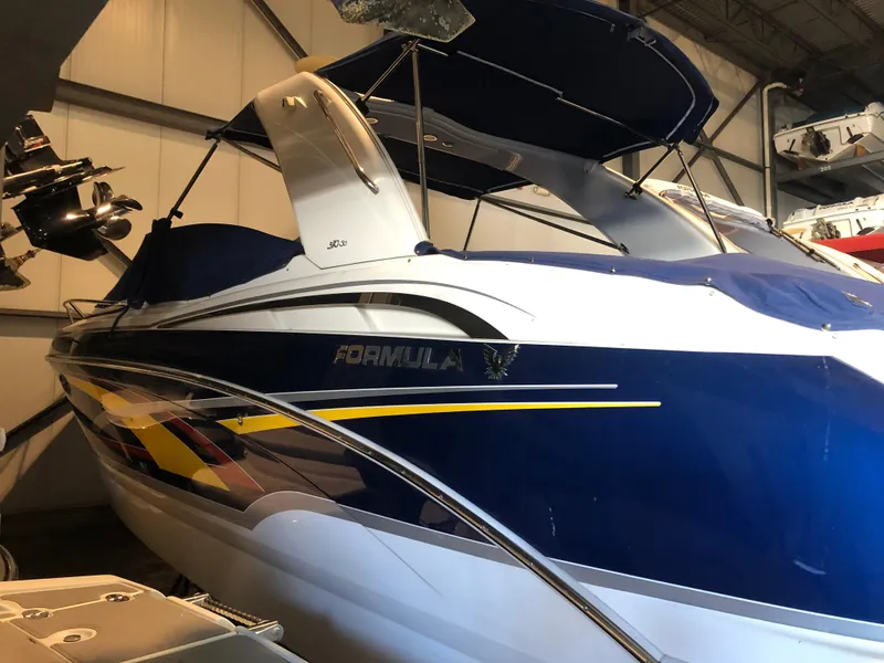 Slide: The Image of 2008 Formula 310 Sun Sport boat in storage, featuring sleek blue and white design. - 3