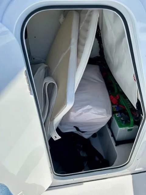 Slide: The Image of 2024 Sportsman Open 232 Center Console storage compartment with cushions and gear. - 12