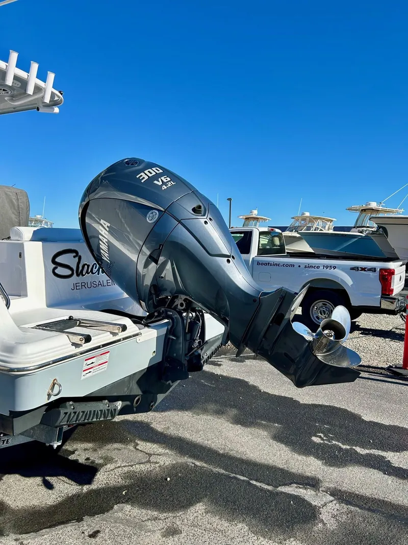 Slide: The Image of 2024 Sportsman Open 232 Center Console with powerful 300 V6 engine, parked outdoors. - 24