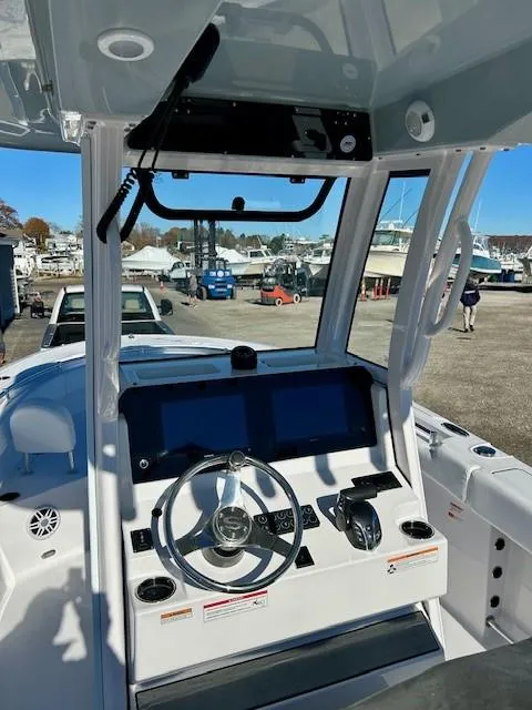 Slide: The Image of 2024 Sportsman Open 232 Center Console boat dashboard with steering wheel and controls. - 7