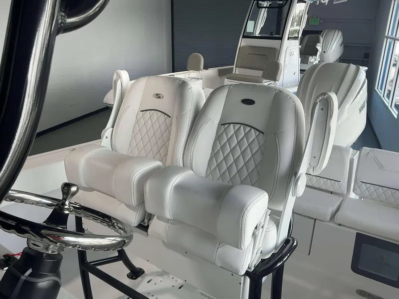 Slide: The Image of 2025 Sportsman 231 Heritage boat interior with luxurious white seating and steering wheel. - 13