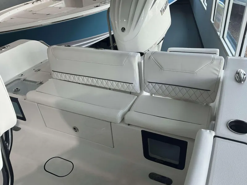 Slide: The Image of 2025 Sportsman 231 Heritage boat interior with white cushioned seating and storage compartments. - 7