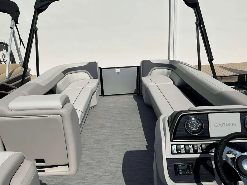 Slide: The Image of 2025 Sweetwater 2286 C pontoon boat interior with gray seating and Garmin dashboard. - 10