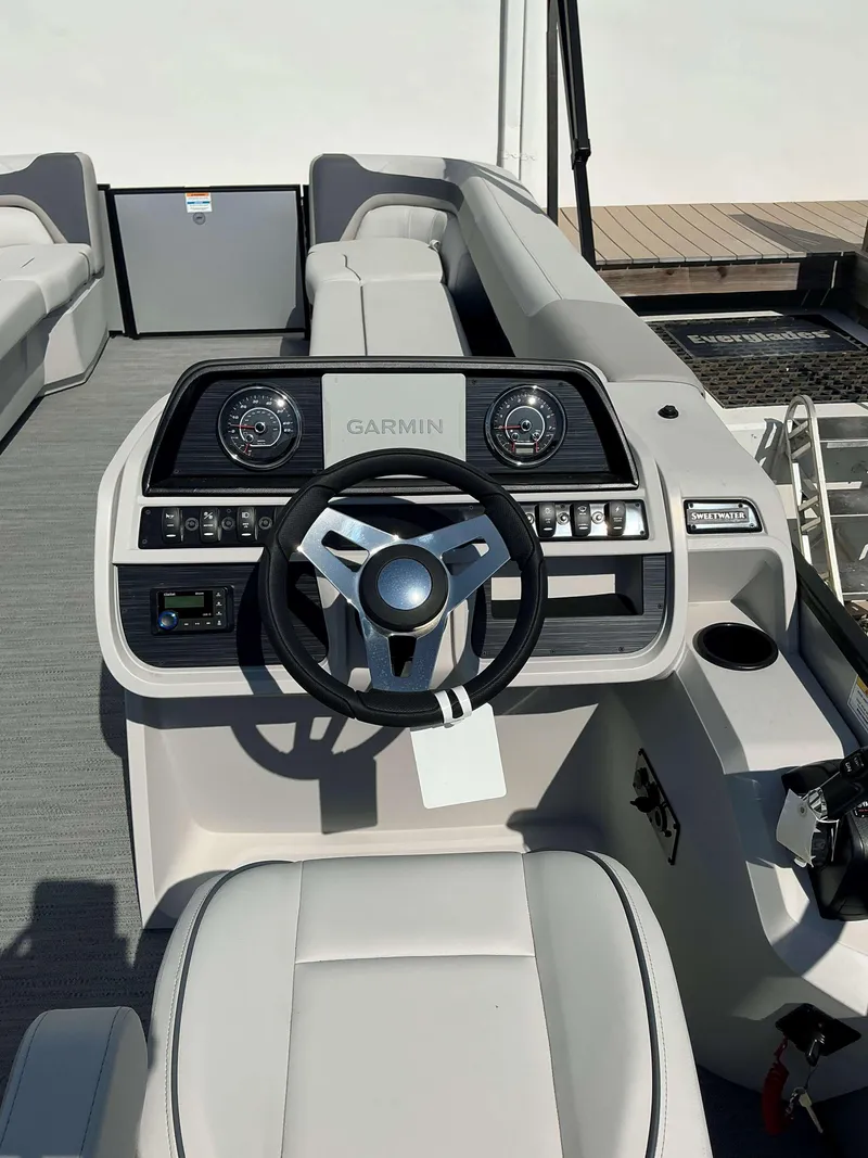 Slide: The Image of 2025 Sweetwater 2286 C boat dashboard with Garmin navigation system and steering wheel. - 12