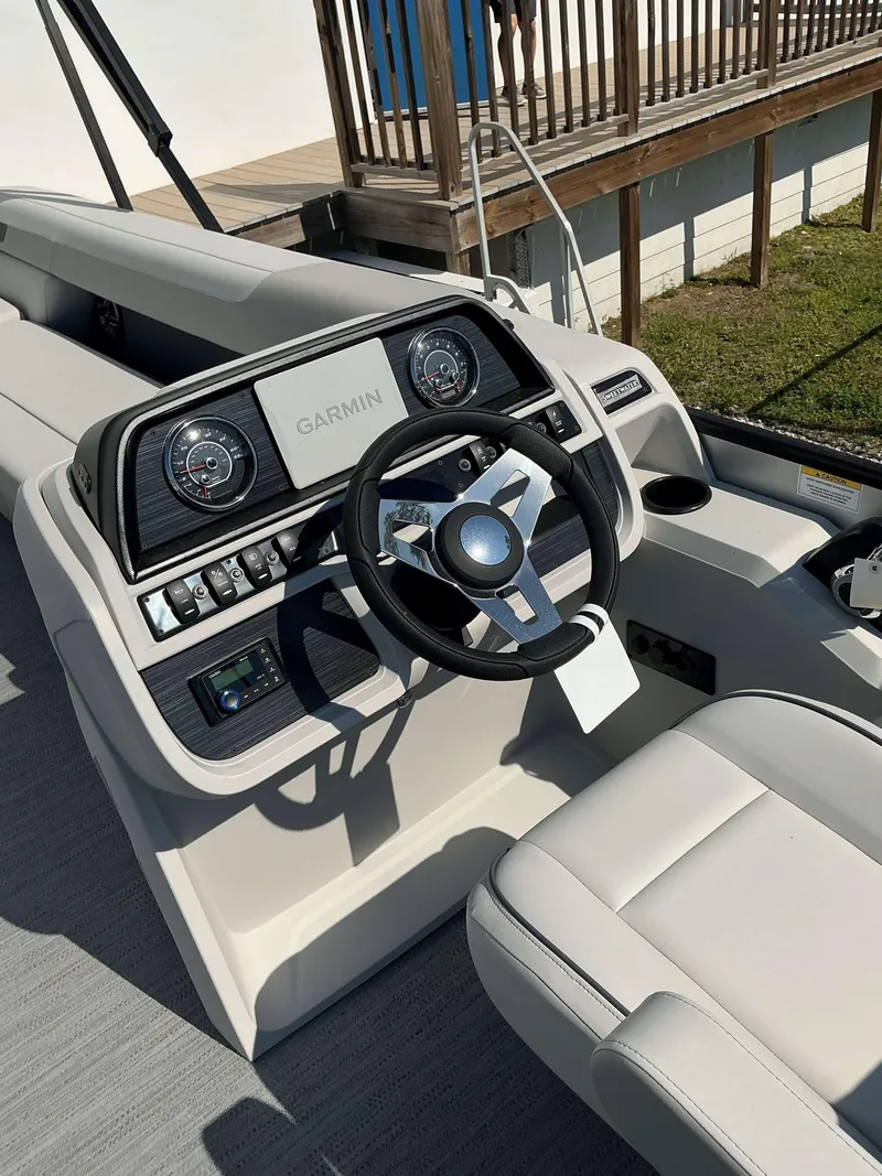 Slide: The Image of 2025 Sweetwater 2286 C boat dashboard with Garmin navigation system and steering wheel. - 13