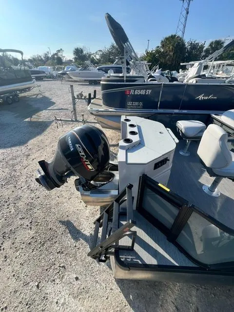 Slide: The Image of 2025 Sweetwater 2286 FS boat with outboard motor in a sunny marina. - 6