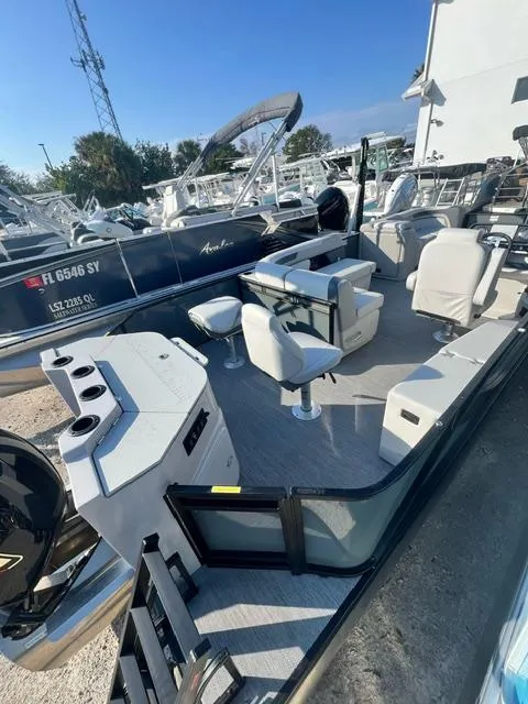 Slide: The Image of 2025 Sweetwater 2286 FS boat interior with seating and console, docked outdoors. - 7
