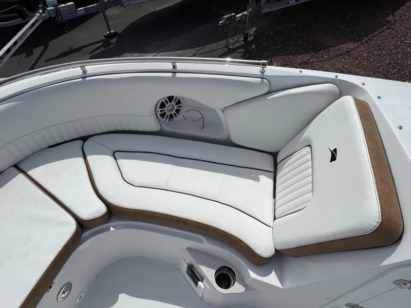 Slide: The Image of 2025 Stingray 231 DC boat interior with white and brown cushioned seating. - 15