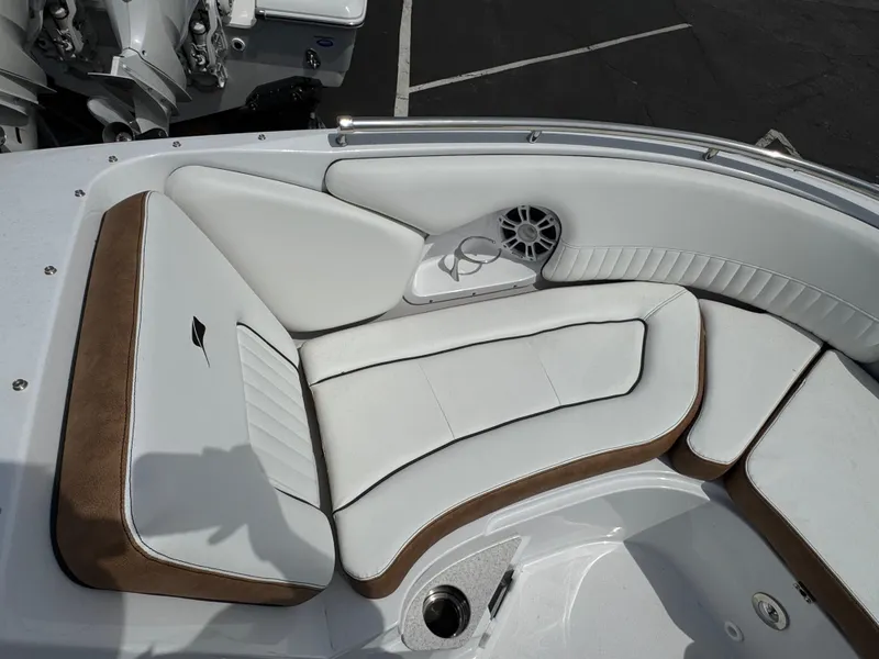 Slide: The Image of 2025 Stingray 231 DC boat interior with white and brown cushioned seating. - 16