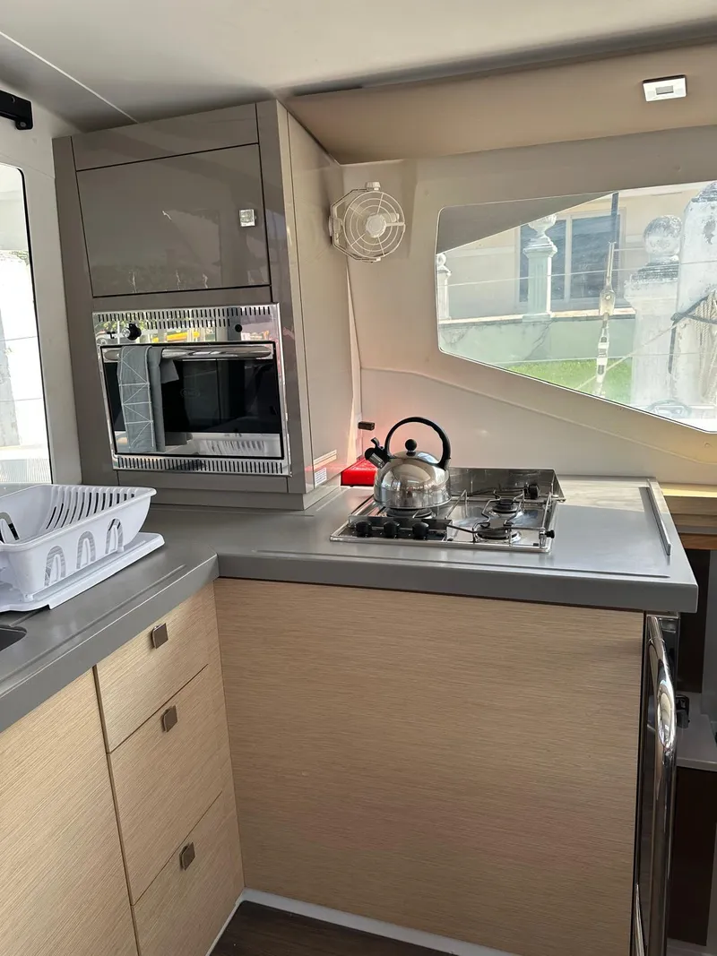 Slide: The Image of Interior of 2019 Fountaine Pajot Lucia 40 yacht kitchen with stove and microwave. - 10