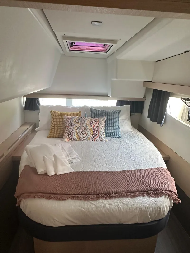 Slide: The Image of Cozy bedroom in 2019 Fountaine Pajot Lucia 40 catamaran with colorful pillows and soft lighting. - 14