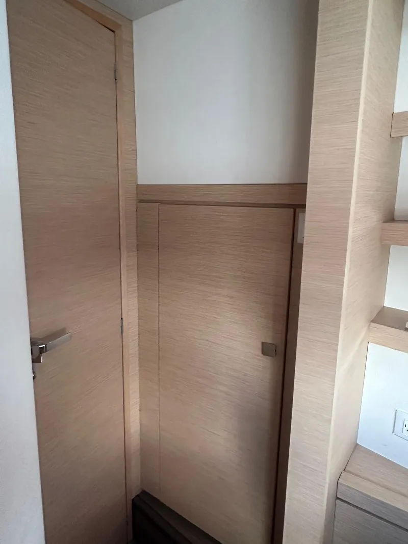 Slide: The Image of Interior of 2019 Fountaine Pajot Lucia 40 yacht, featuring wooden cabinetry and door. - 27