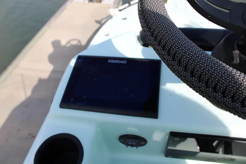 Slide: The Image of Close-up of 2021 ZCB 26 Freemason boat dashboard with Simrad display and steering wheel. - 8