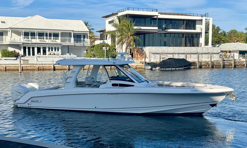 Slide: The Image of 2018 Boston Whaler 350 Realm boat docked near waterfront homes. - 1
