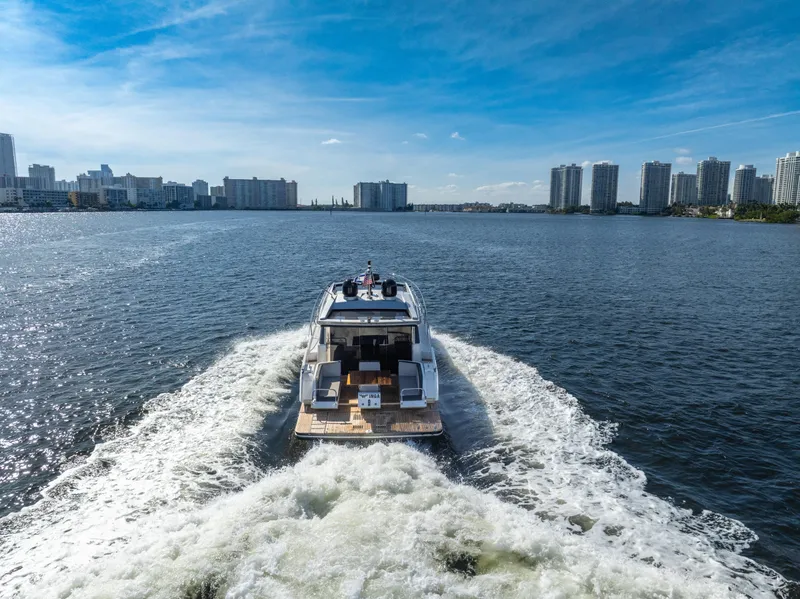 Slide: The Image of Galeon 430 HTC yacht cruising on a sunny day, city skyline in background. - 12