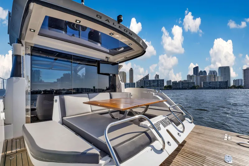 Slide: The Image of Galeon 430 HTC 2016 yacht with city skyline, spacious deck, and seating area. - 43