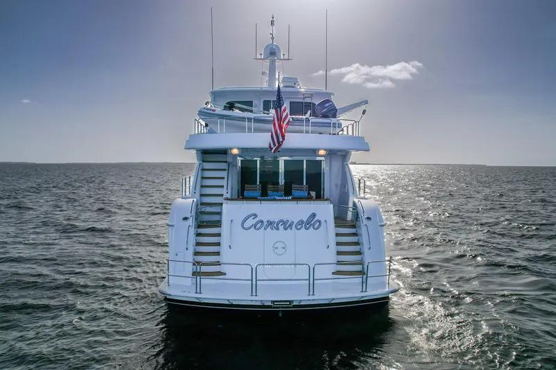 Slide: The Image of 2007 Hatteras 80 Motor Yacht on open water, rear view with American flag. - 14