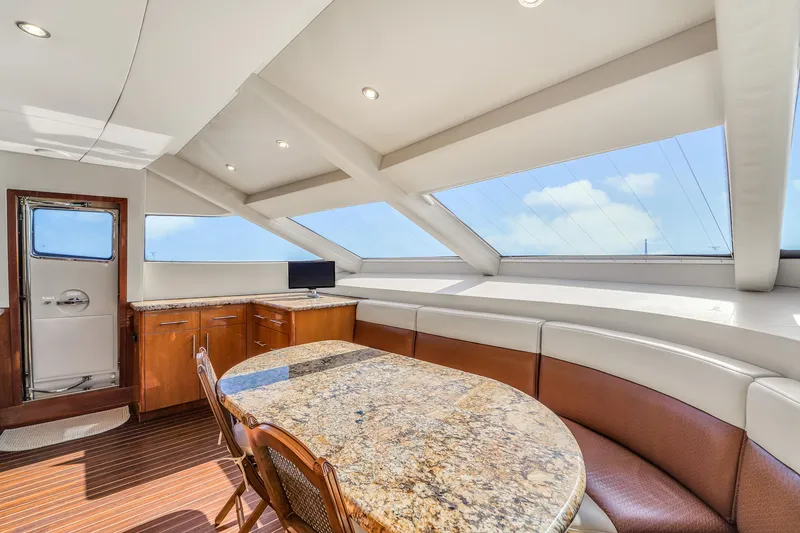 Slide: The Image of Luxurious interior of 2007 Hatteras 80 Motor Yacht with elegant dining area and panoramic windows. - 49